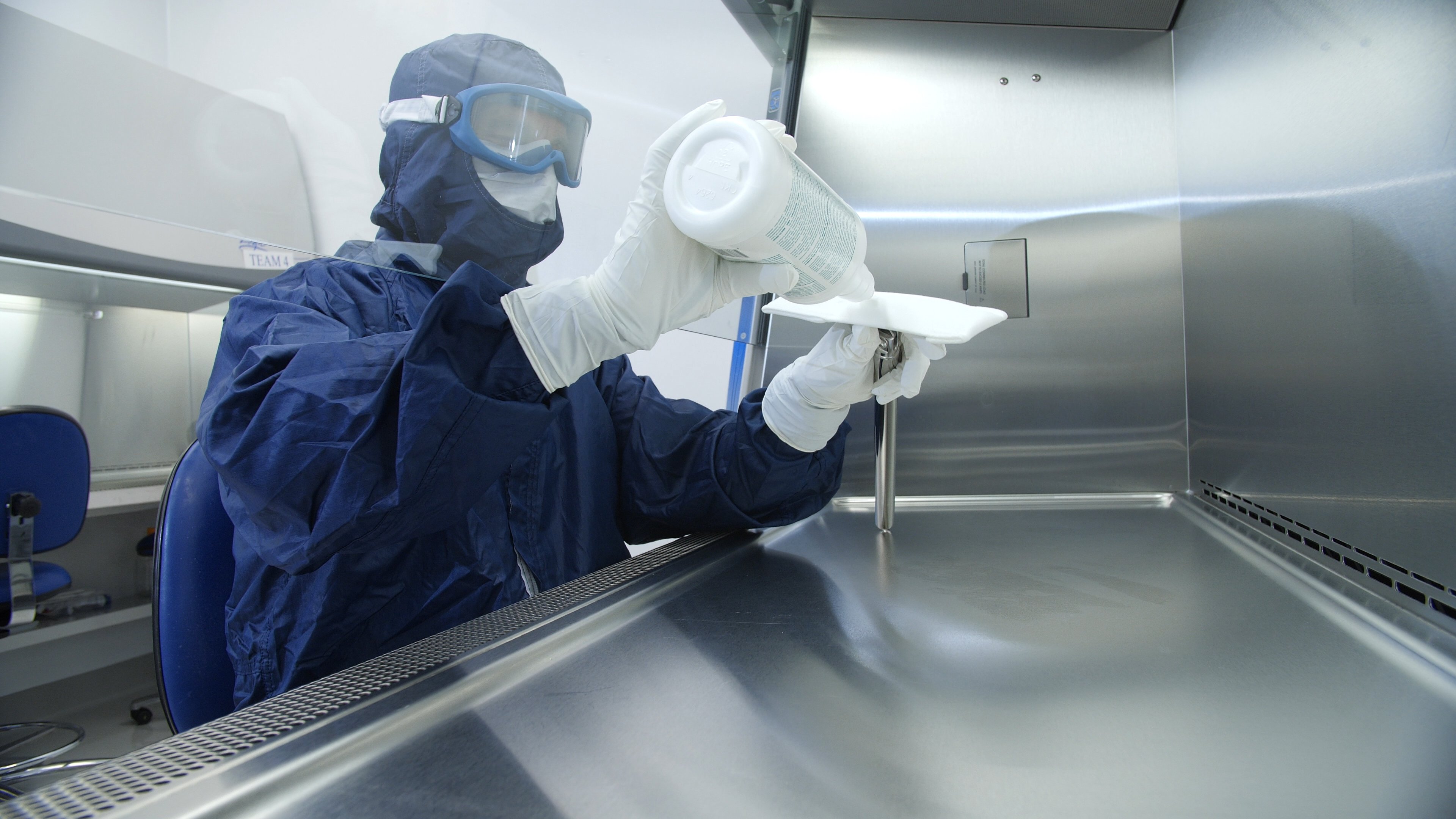 cleanroom worker applying disinfectant to easy reach tool
