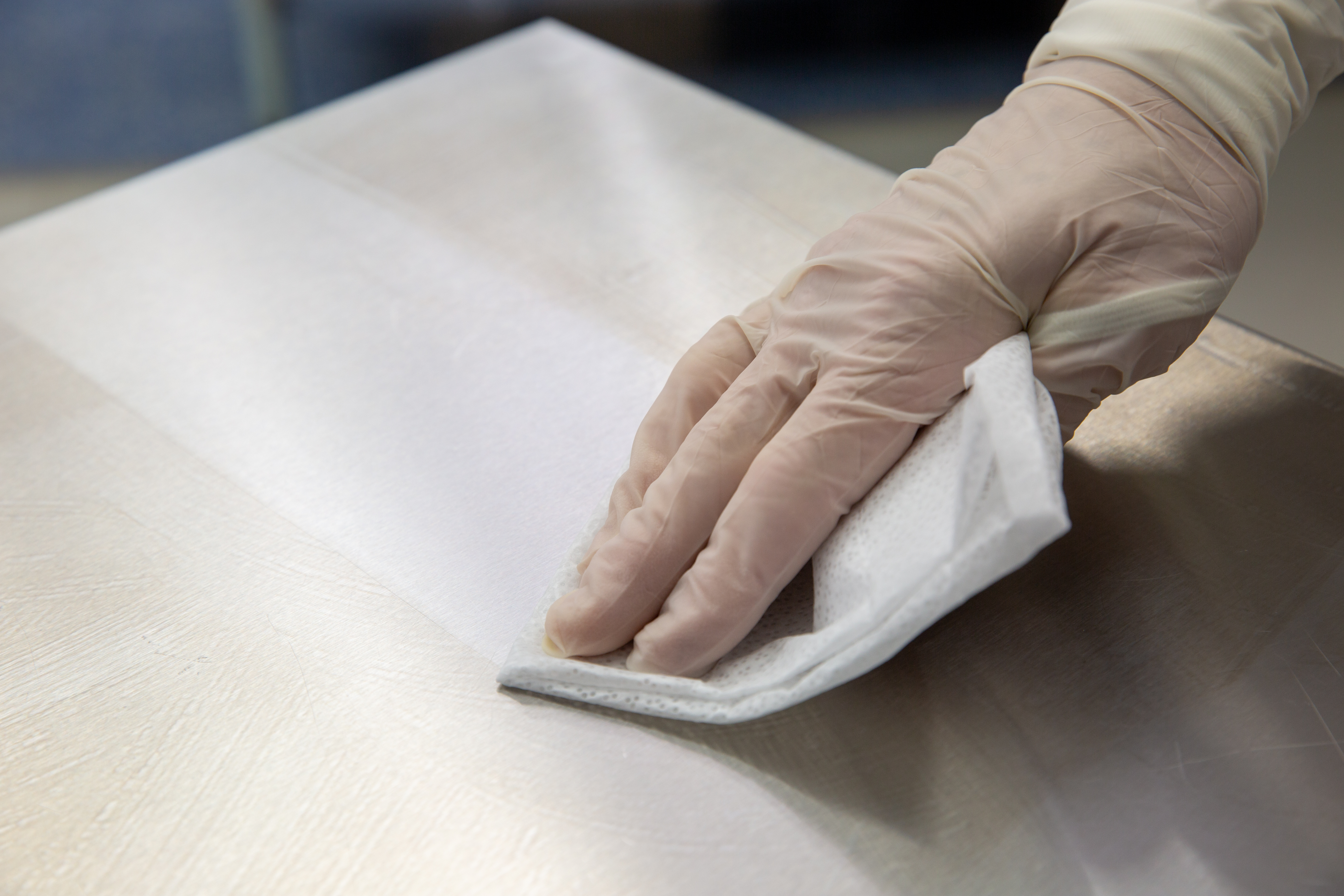 gloved hand wiping residue in cleanroom